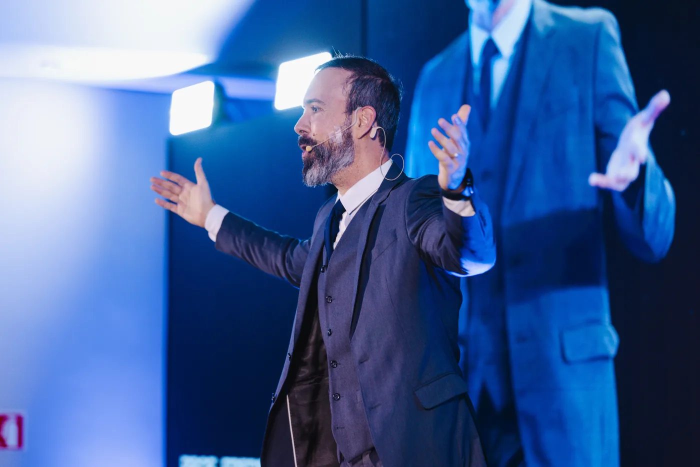 Prof. Frederico Martins ensinando em um palco iluminado por luz azul